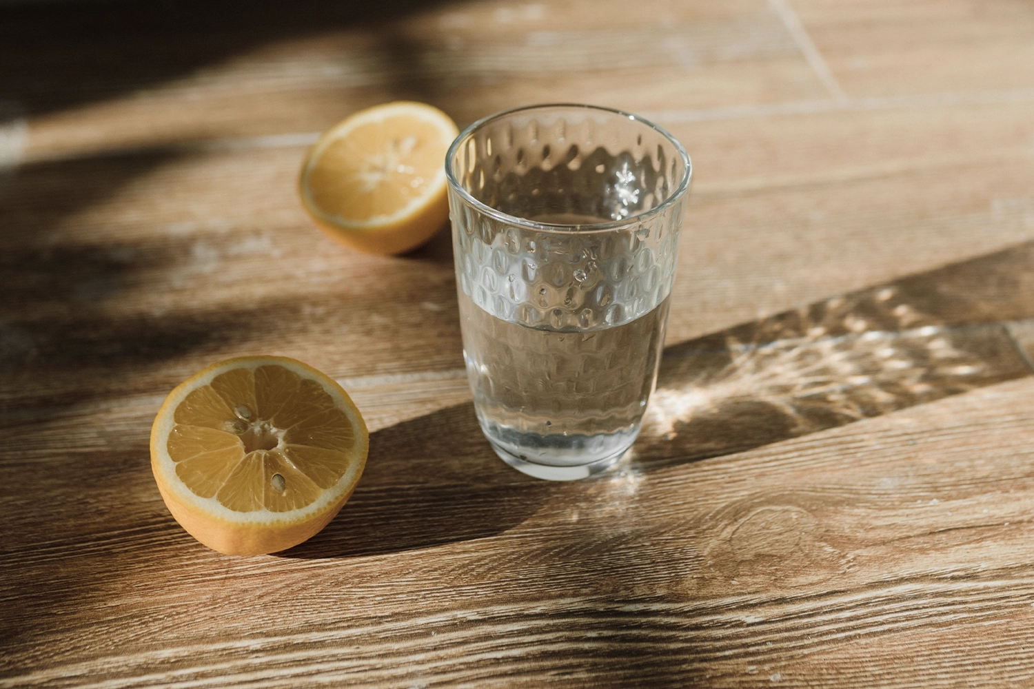 glass of water with lemon halves on a 